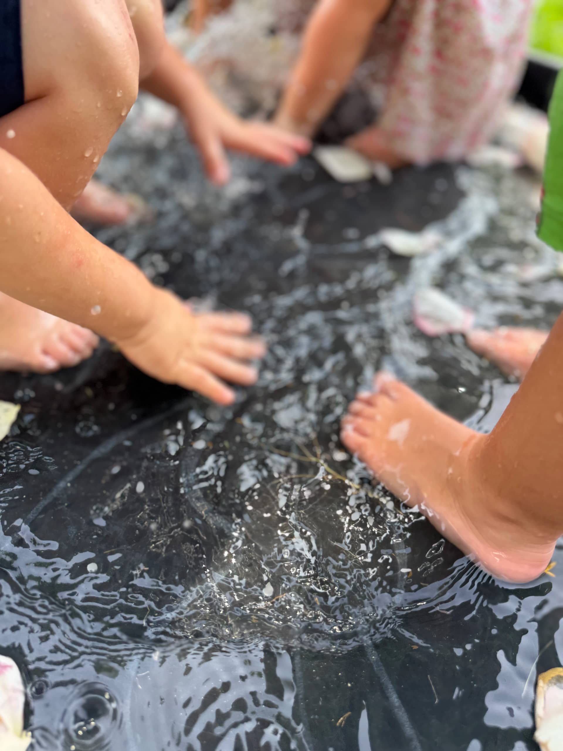 Children splashing barefoot in outdoor water play